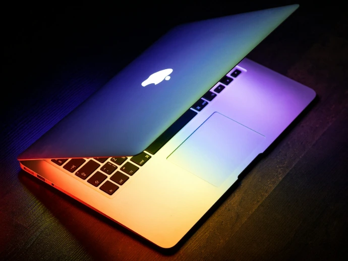 MacBook on a wooden desk — SentinelOne protects Windows, macOS and Linux