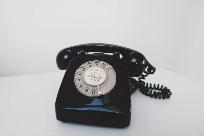 oud zwart telefoontoestel met draaischijf